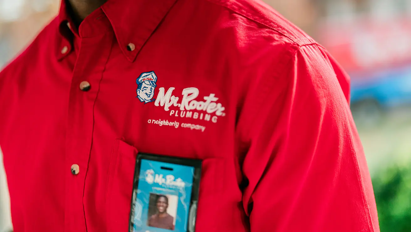 Close up portrait of Mr. Rooter branded work shirt.