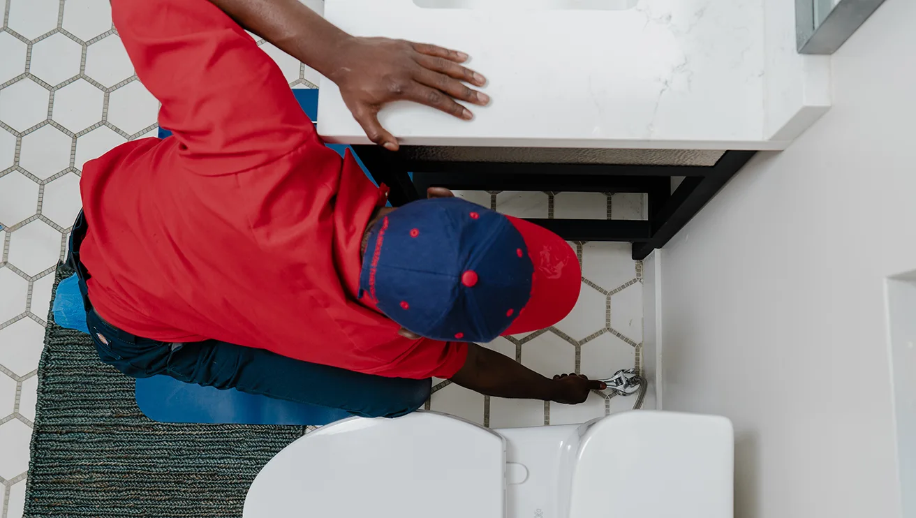 Mr. Rooter technician fixing a toilet water valve.