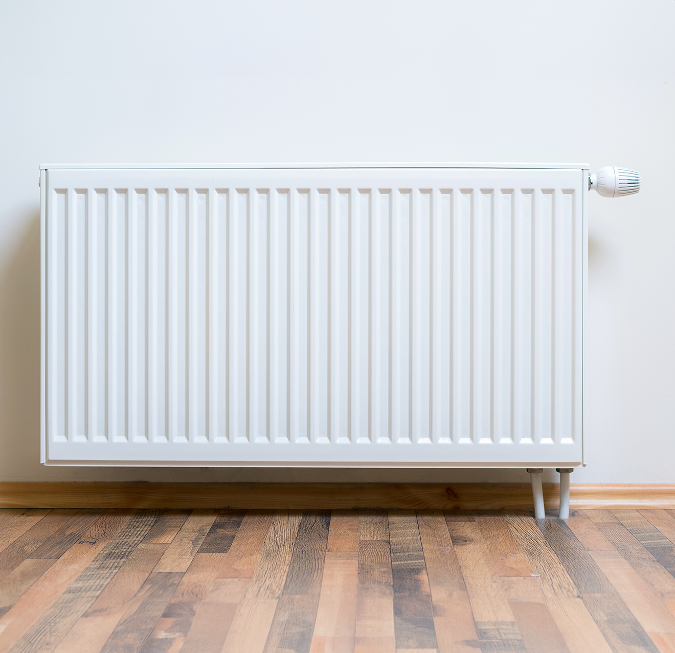 Photo of a radiator against a neutral colored wall.