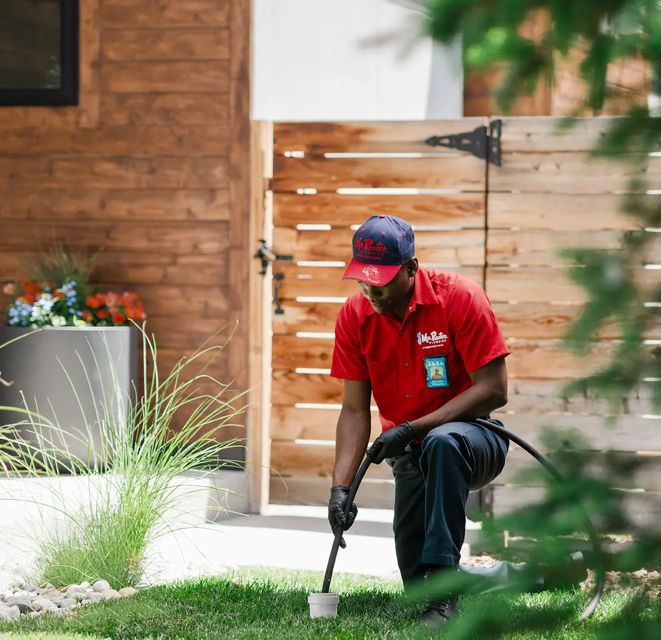 Mr. Rooter technician cleaning a sewer drain on the exterior of a business.