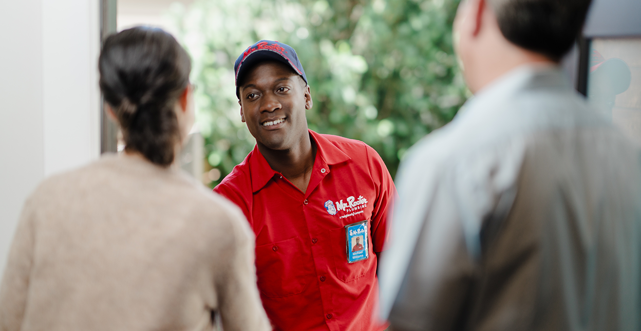 Mr Rooter technician greeting customer's at their door.