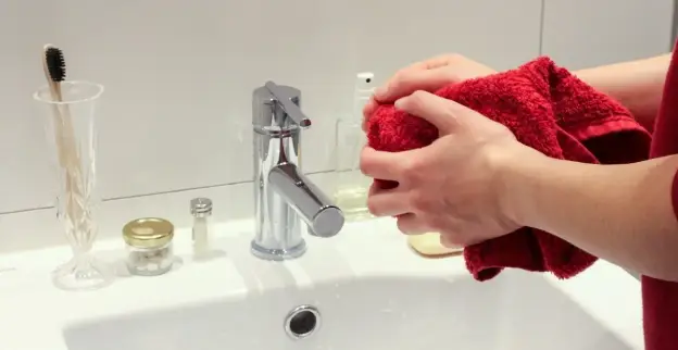 A plumber drying their hands after completing faucet installation in Mississauga, ON