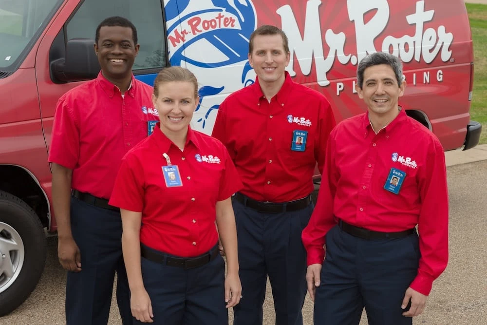 Mr. Rooter of Ottawa Arnprior team members smiling in front of van.