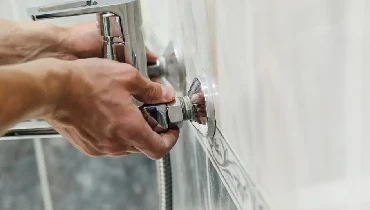 Plumber replacing a bathtub faucet.