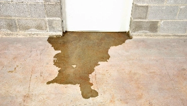 Water flowing under the door of a flooded basement in Regina, SK