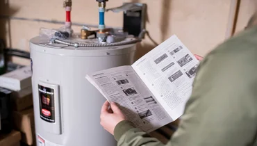 Person reading water heater manual