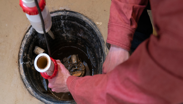 Person cleaning out a sump pump