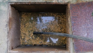 A hose being inserted into a sewer cleanout to remove the dirty waste water that has filled the cleanout because of a sewer backup.