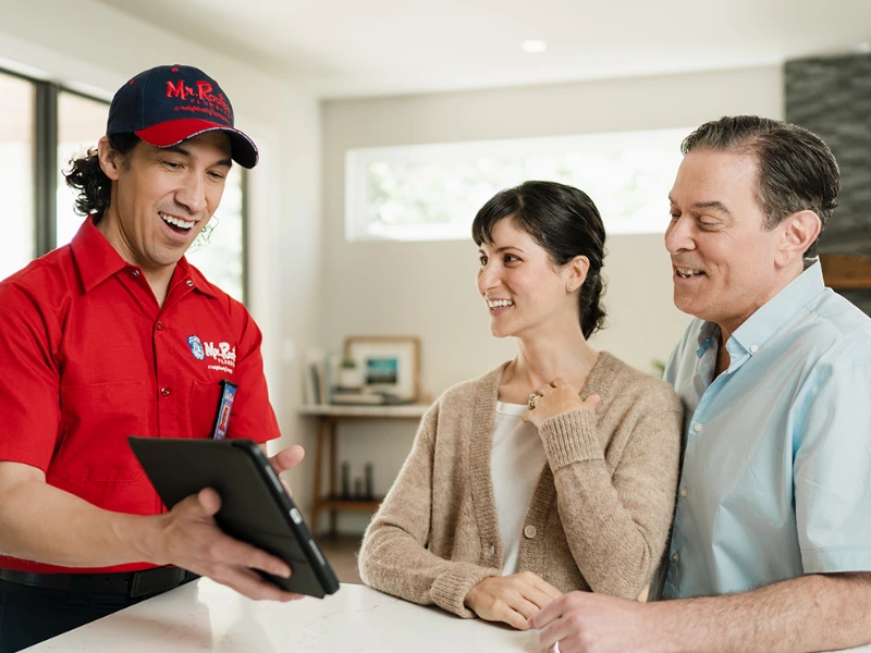 Mr. Rooter professional speaking with two customers.